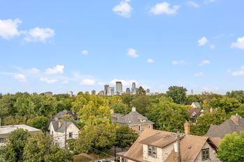 A city skyline is visible in the distance behind a row of houses.